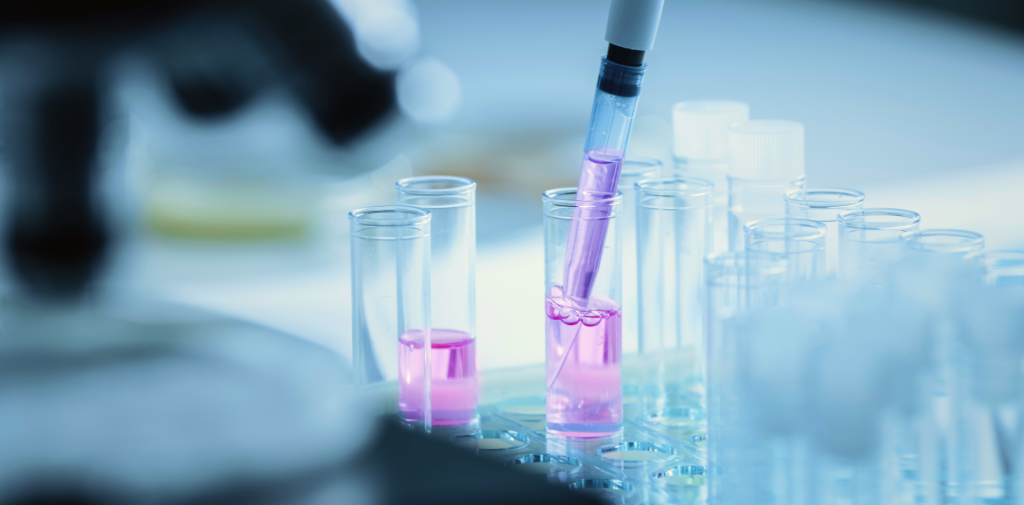 close-up of pipettes filled with purple liquid in beakers